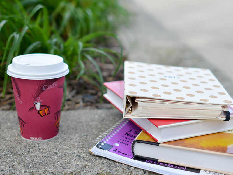 Cup of Coffee and stack of books at affordable Christian colleges
