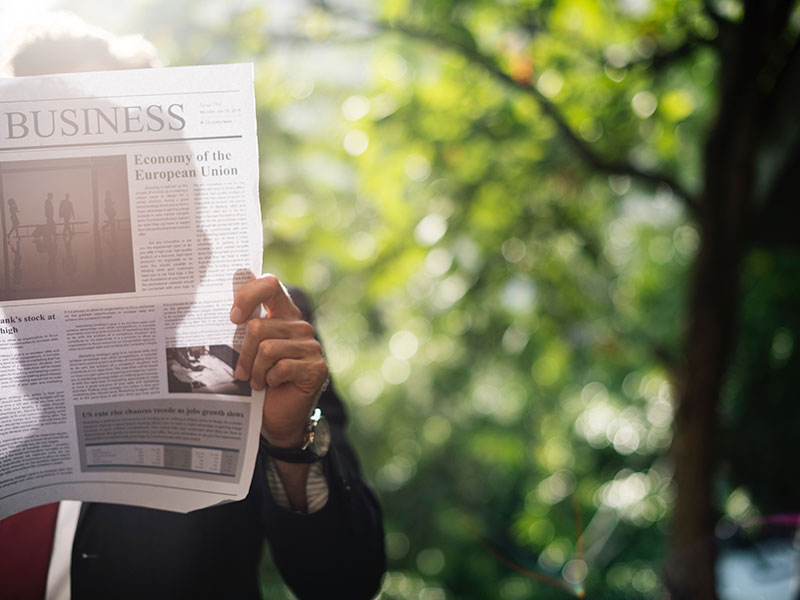 Holding a newspaper with a Business Management Degree