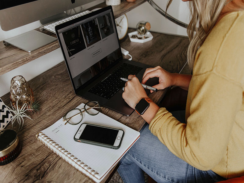 Girl with yellow sweater sitting at desk
