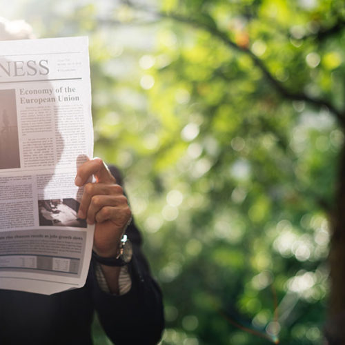 Holding a newspaper with a Business Management Degree