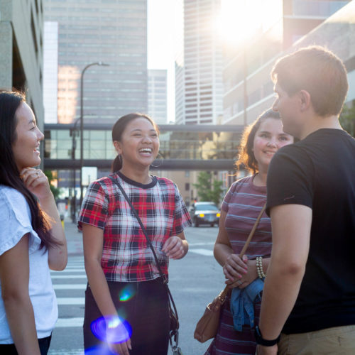 Group of students talking to each other on a sidewalk in downtown Minneapolis