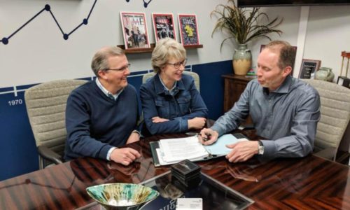 Two people meeting with a planner to discuss their futures.