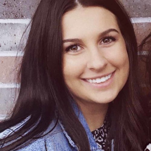 DeBoef smiling in front of a brick wall