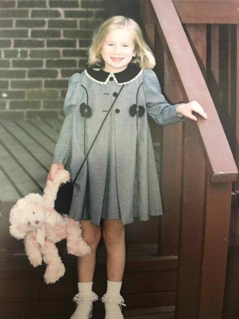 girl in grey dress with teddy bear