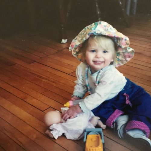 Nicole in colorful hat as a baby