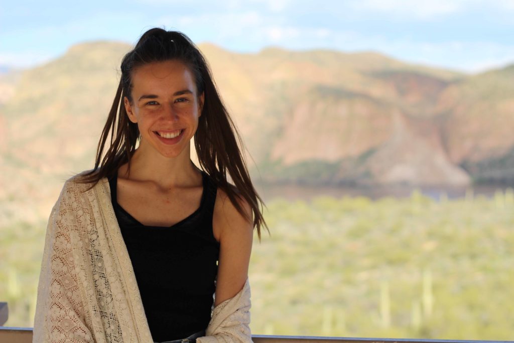 Girl in black shirt smiling outside