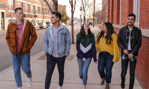 Group of students walking on a sidewalk in the city