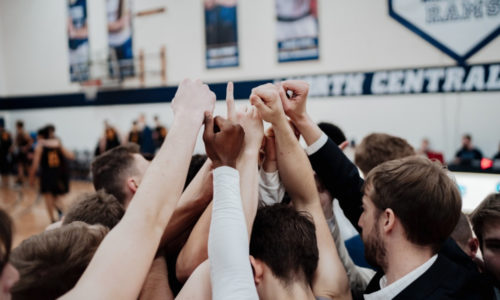 Basketball players huddled before a game