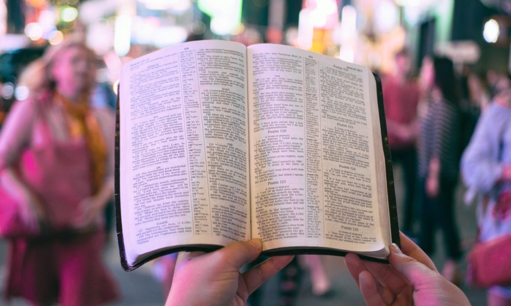 Person in the city reading the bible