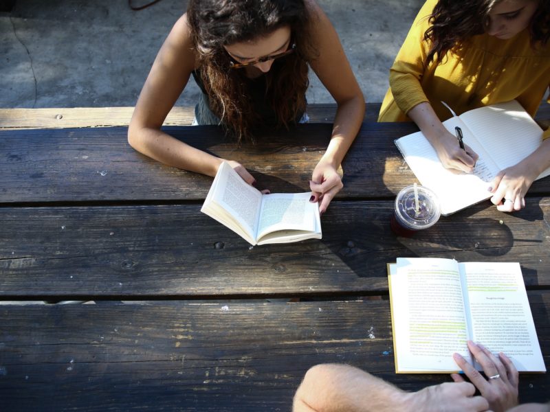 Three people working at a table outside