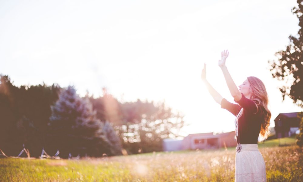 Woman in skirt lifting her hands outside