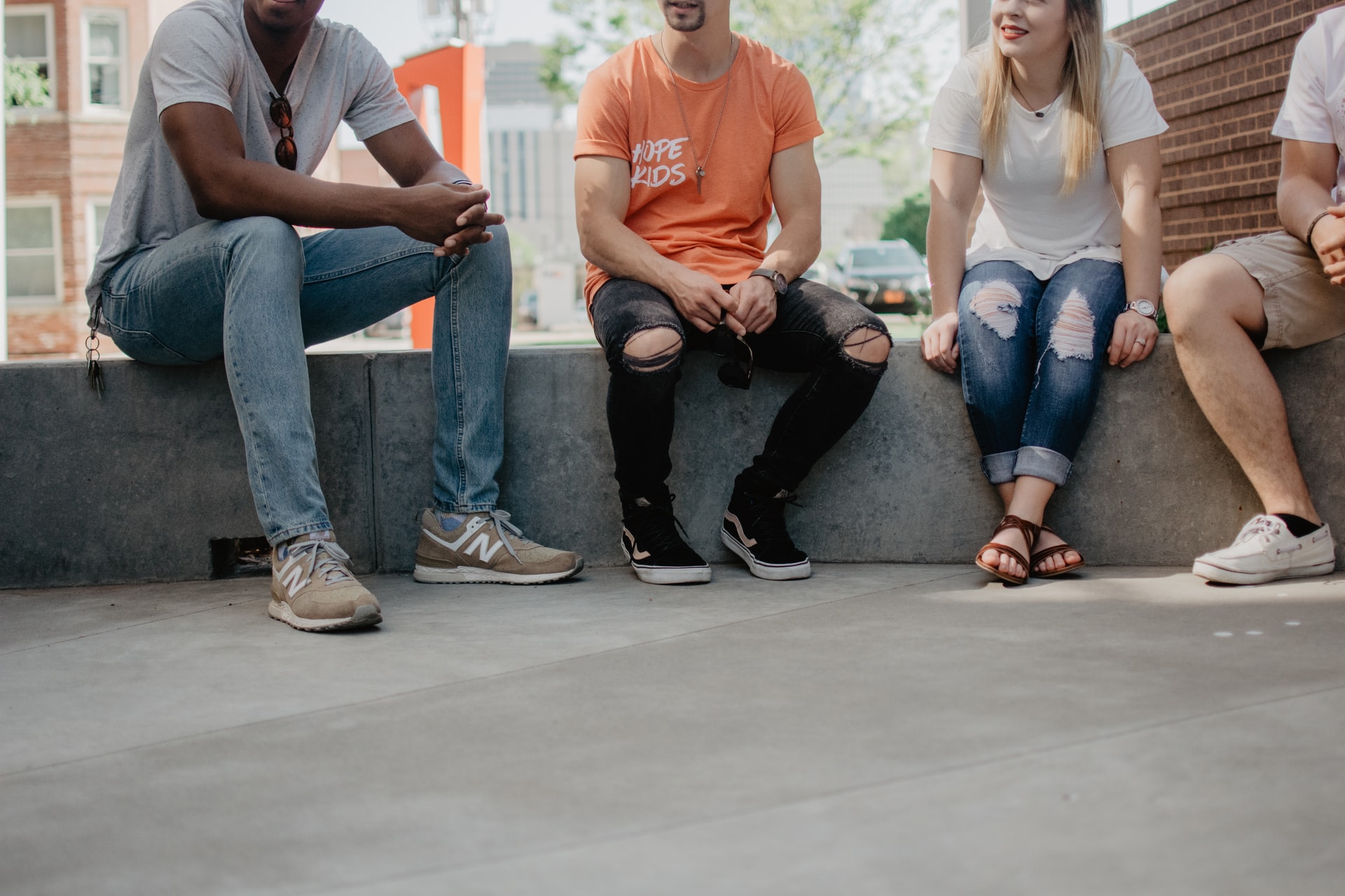 Four students sitting down outside talking