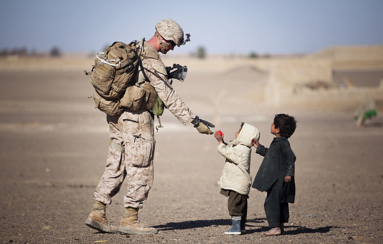 Soldier talking to two small children