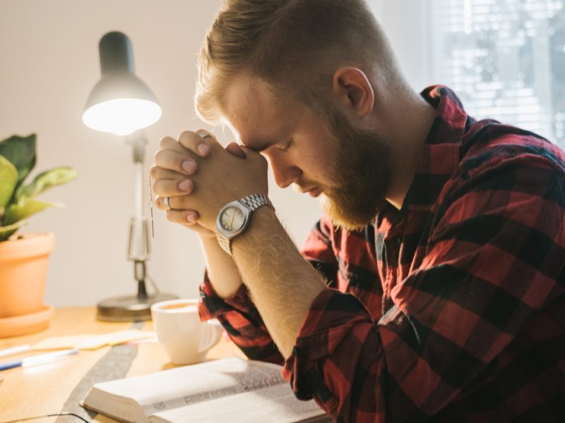 Man sitting at a desk praying