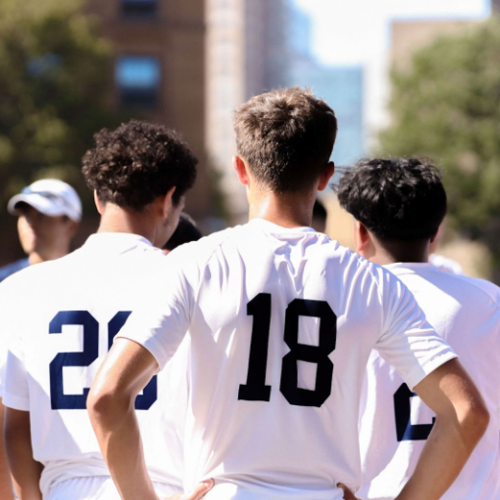 Several athletes stand next to each other, listening intently