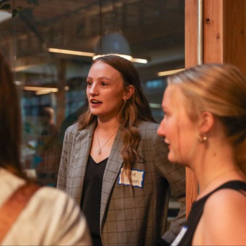 Three women speak to each other at a marketing function