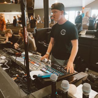 A man stands behind a music console during a live music production