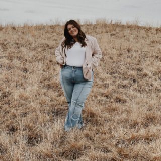 Olivia stands in a field and poses happily for the camera