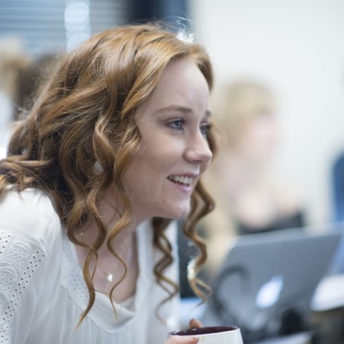 A student smiles and pays close attention during a class