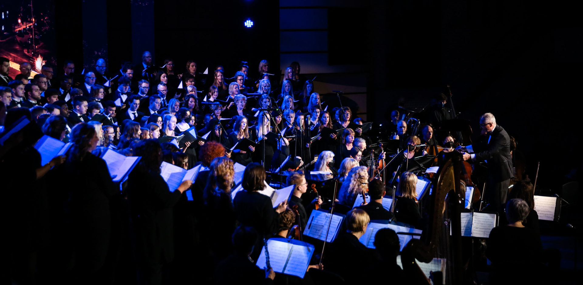 A large concert band performs on-stage during a live performance
