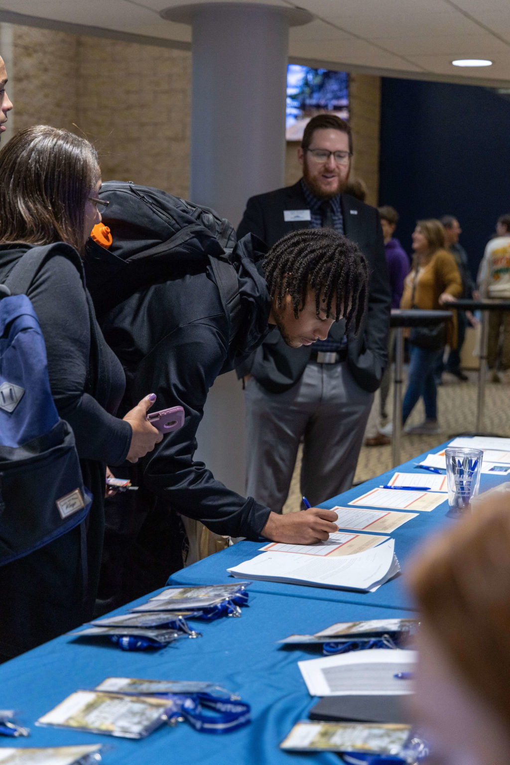 Students line up to fill out forms