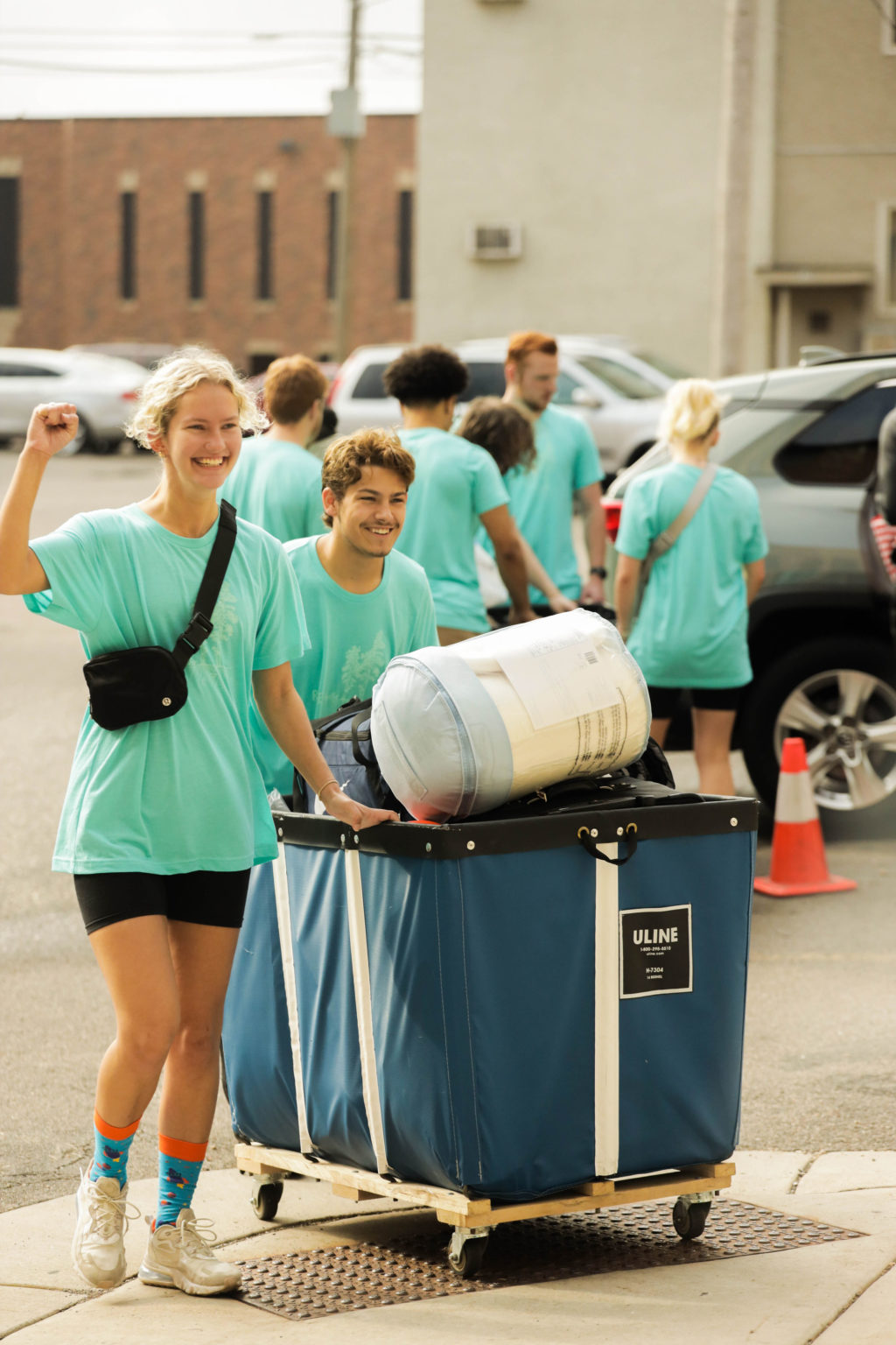 Students in a parking lot loading their things into hampers to bring to their rooms