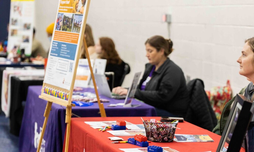 Several vendors are lined up behind their tables, prepared to speak to students