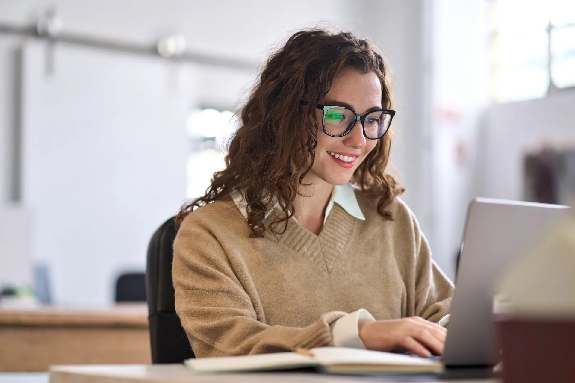 Female NCU student smiling while working on her laptop during a project session