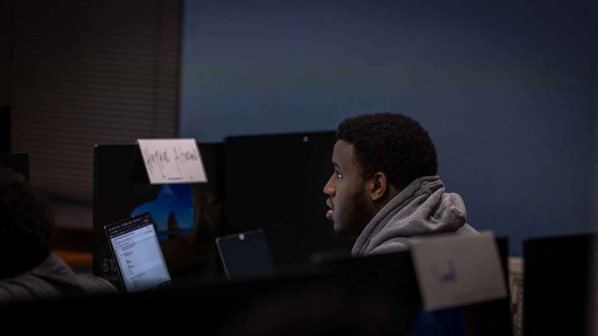 Young professional or early-career NCU student focused on work in a modern office environment