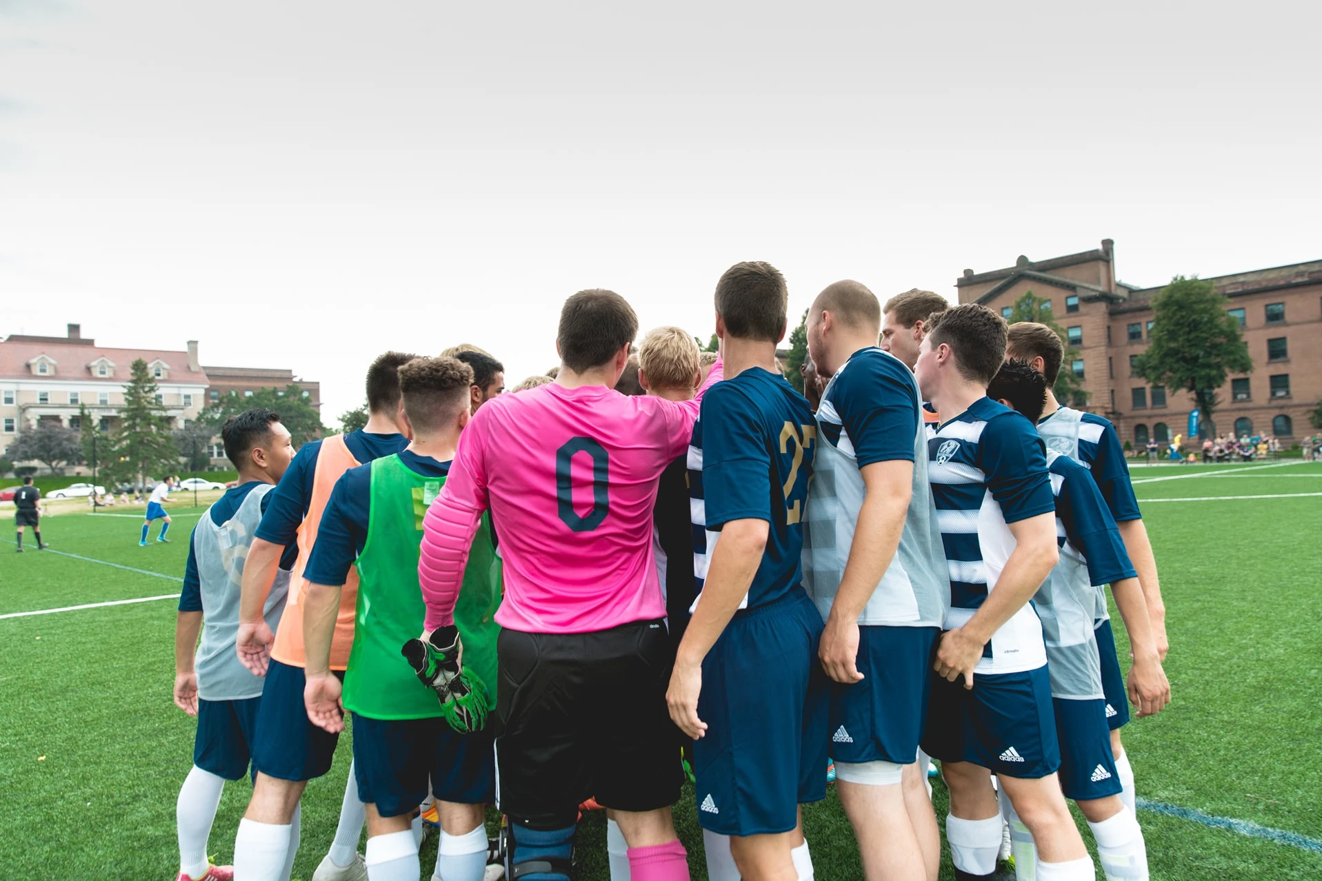 NCU Rams athletes huddling together on field