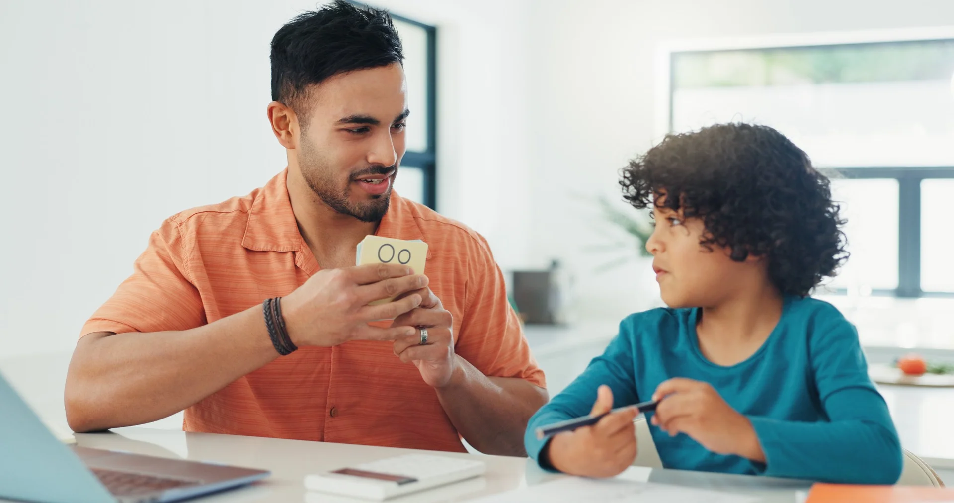 NCU education student teaching a young child using flashcards in a bright classroom setting
