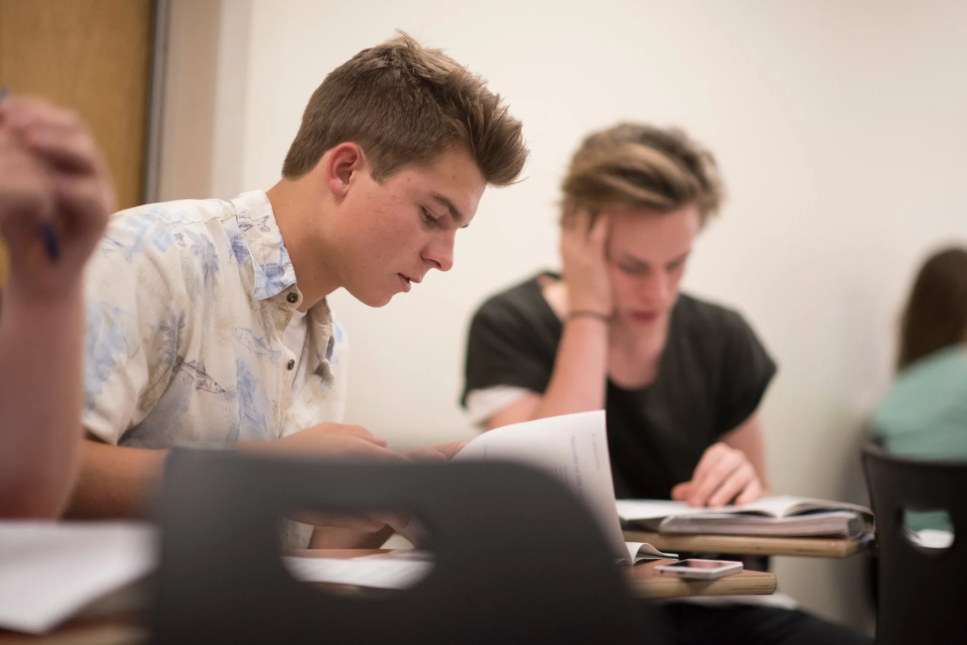 NCU students concentrating on reading and studying during a classroom session