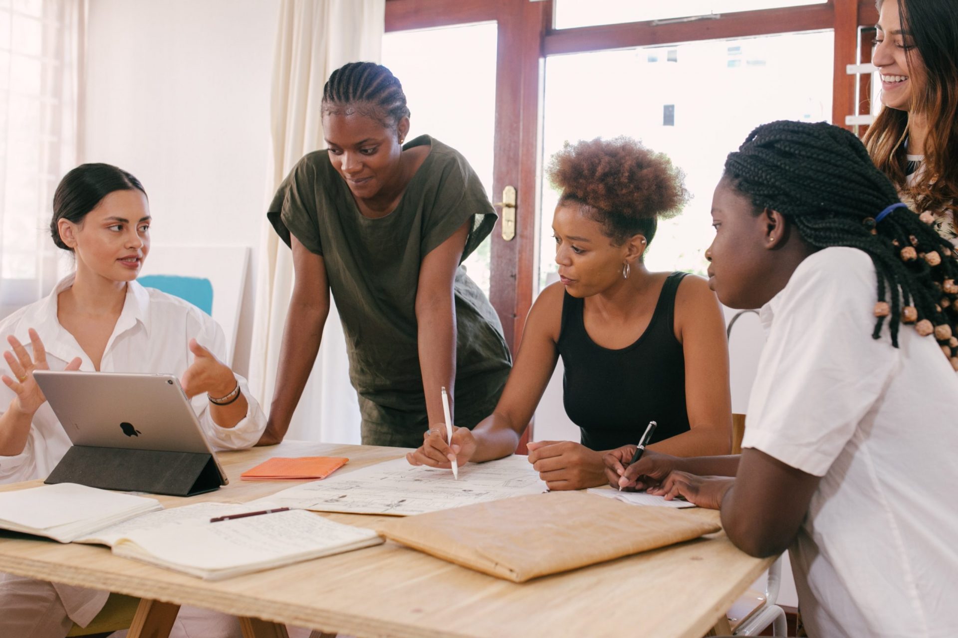 Five students having a conversation at a desk